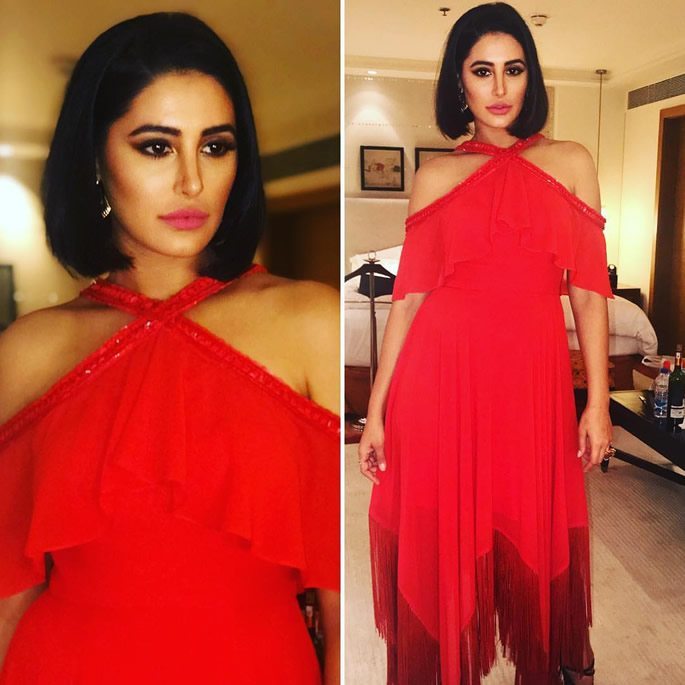 Nargis wears a red, evening gown.