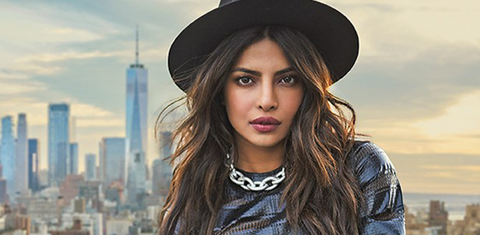 Priyanka Chopra wearing a hat with New York skyline behind her